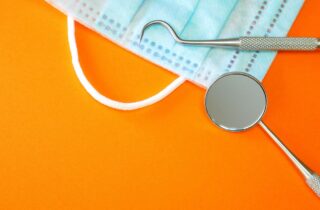 Dentist tools or instruments in dental office: dental explorer, dental mirror and surgical mask coffee and oral health general dentistry dentist in Chapel Hill North Carolina