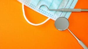 Dentist tools or instruments in dental office: dental explorer, dental mirror and surgical mask coffee and oral health general dentistry dentist in Chapel Hill North Carolina